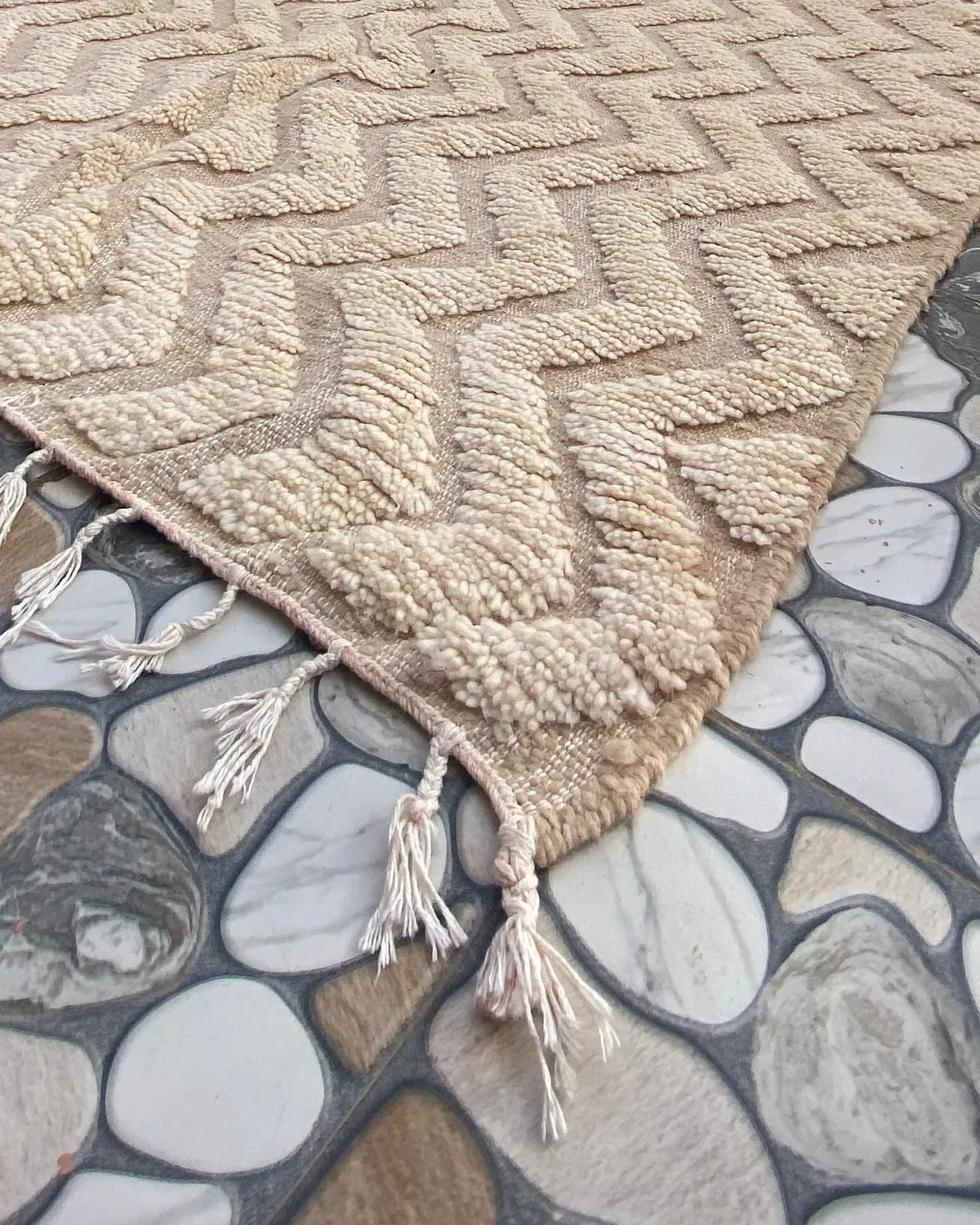 Cream Chevron Beni Ourain Rug, seen at an angle on the workshop floor