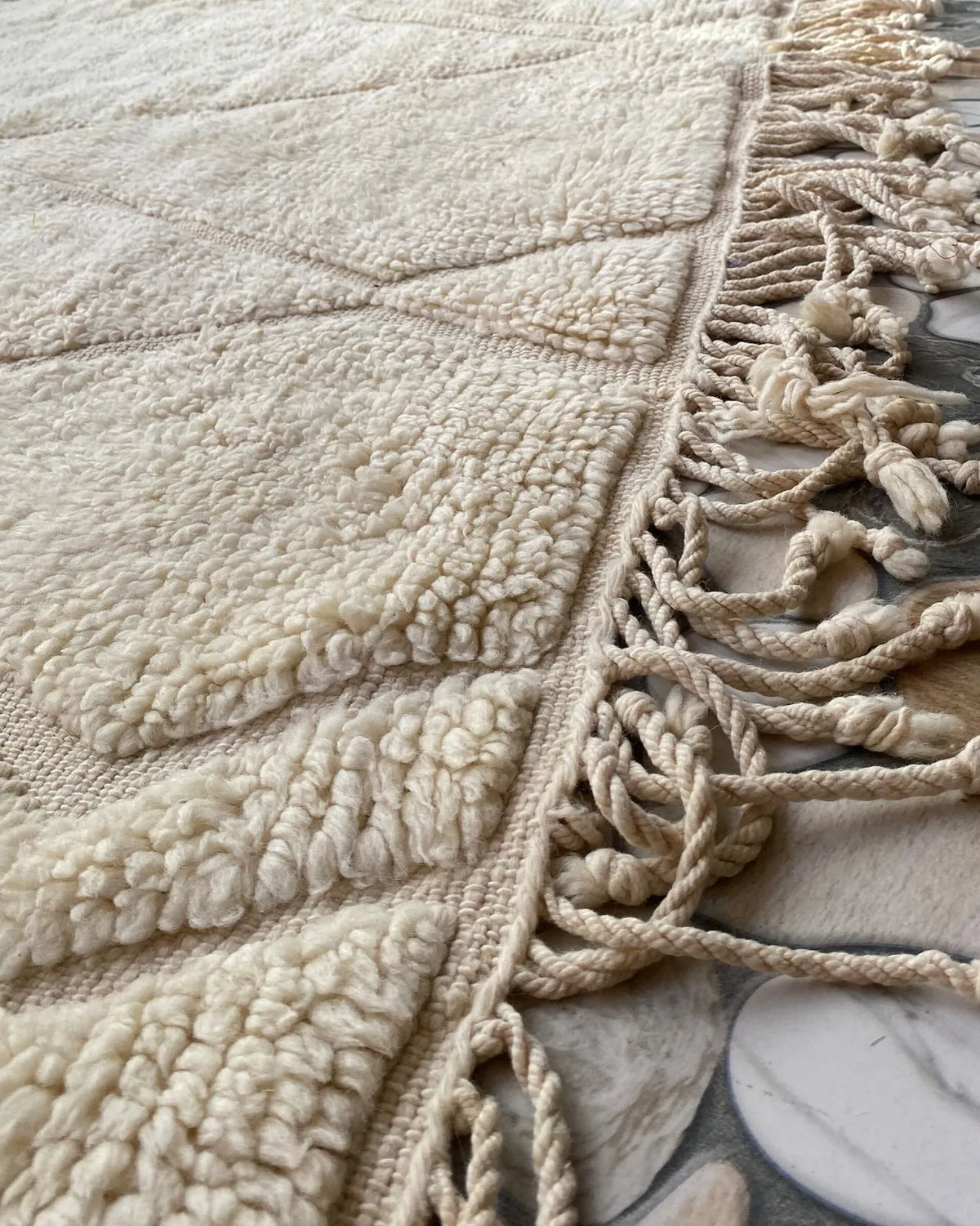 Cream Diamond Relief Beni Ourain Rug, seen at an angle on the workshop floor