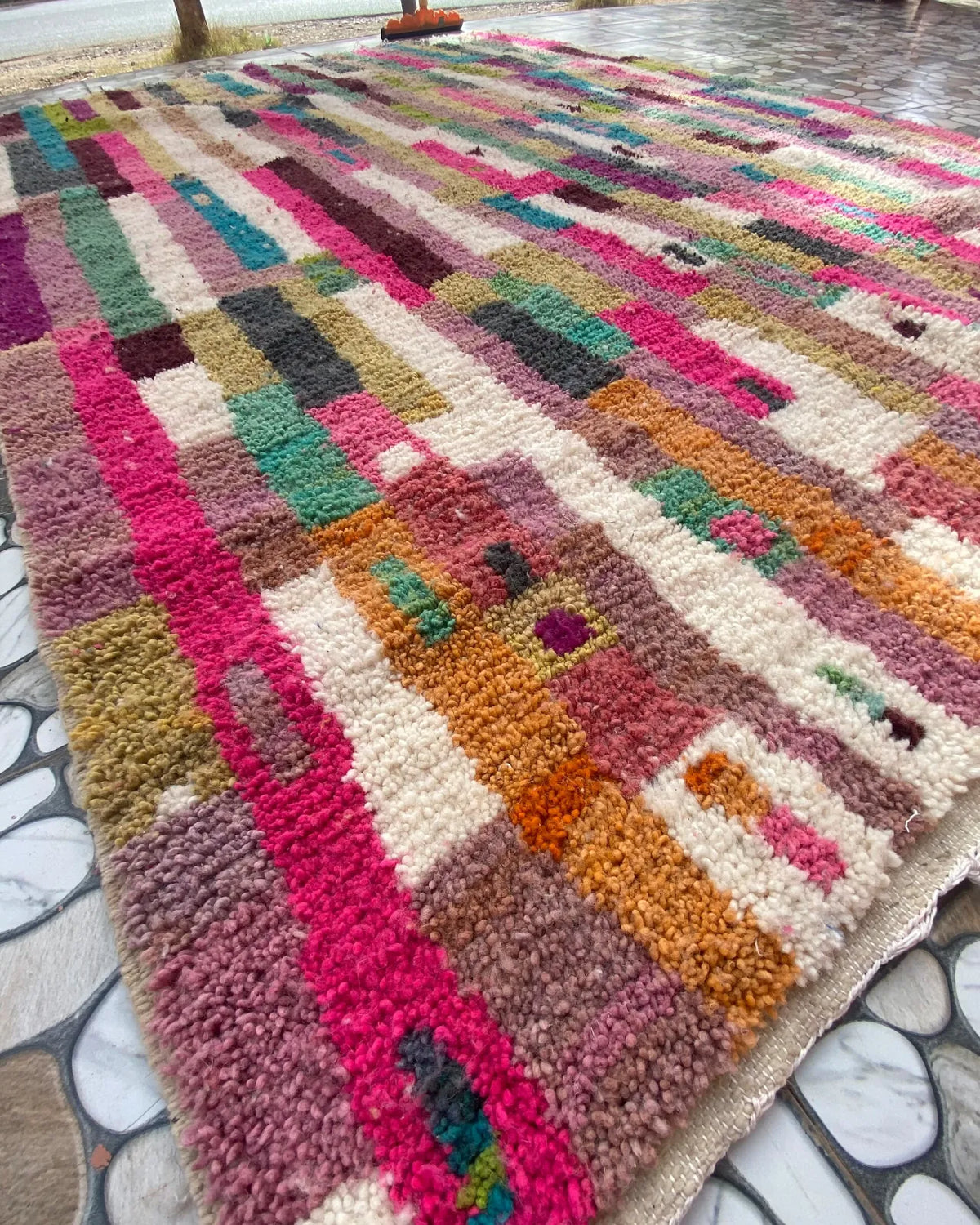 Patchwork Stripe Moroccan Rug, seen at an angle on the workshop floor