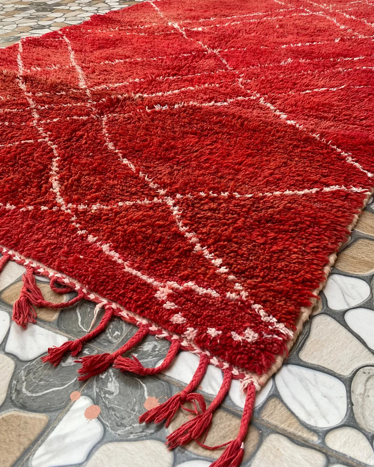 Red Lattice Beni Ourain Rug, seen at an angle on the workshop floor