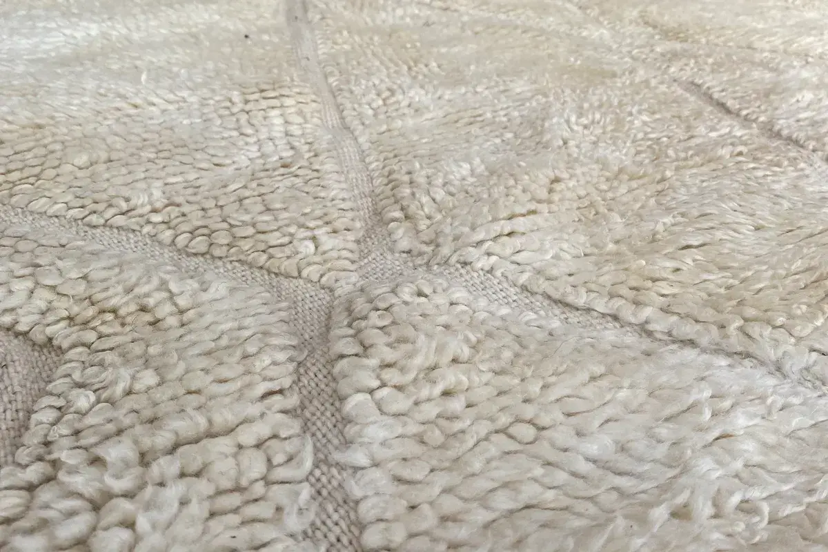 Close-up of a cream wool pile with tone-on-tone diamond lines