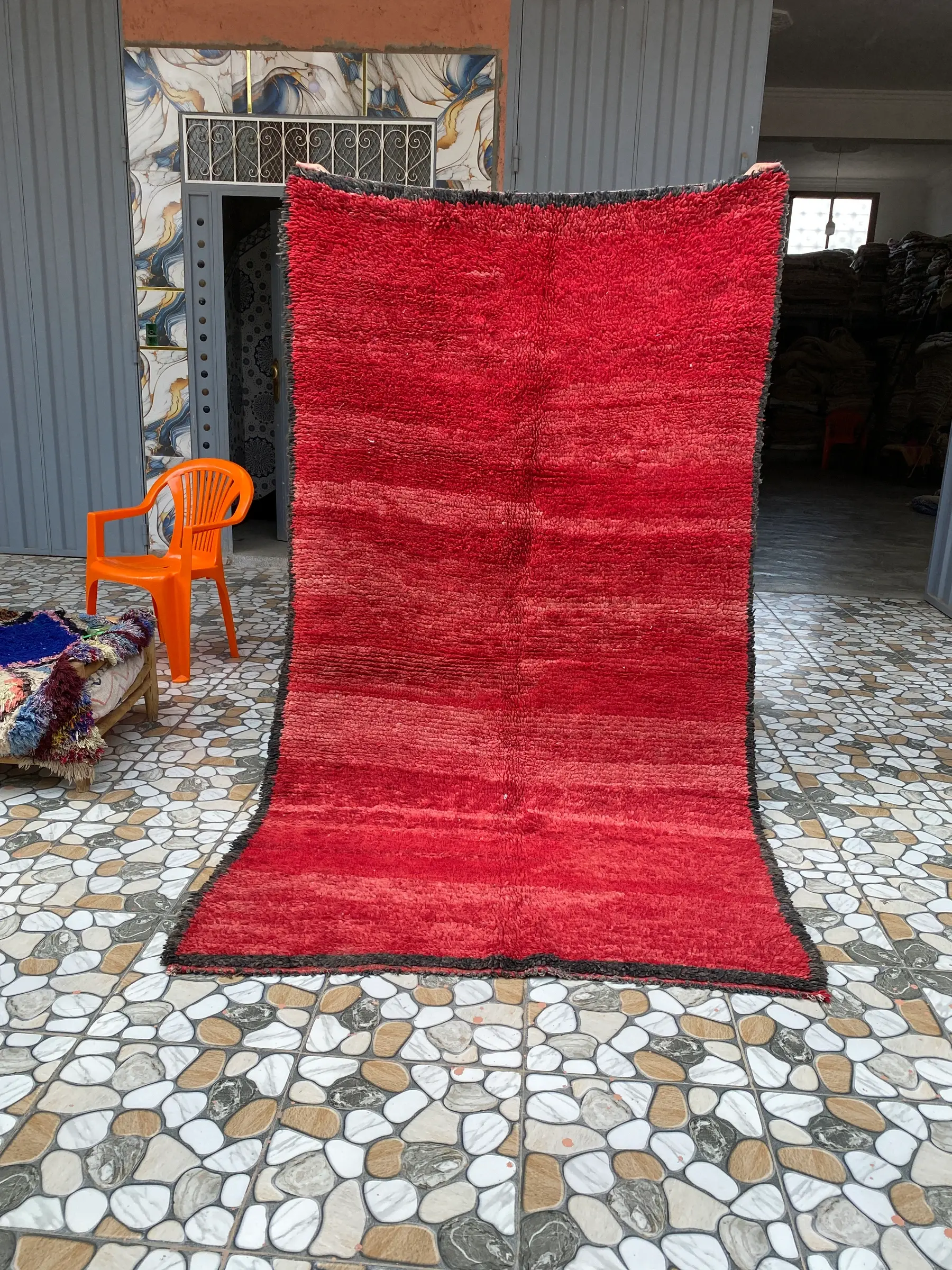 Red and Charcoal Plain Moroccan Rug, held up to show the whole rug