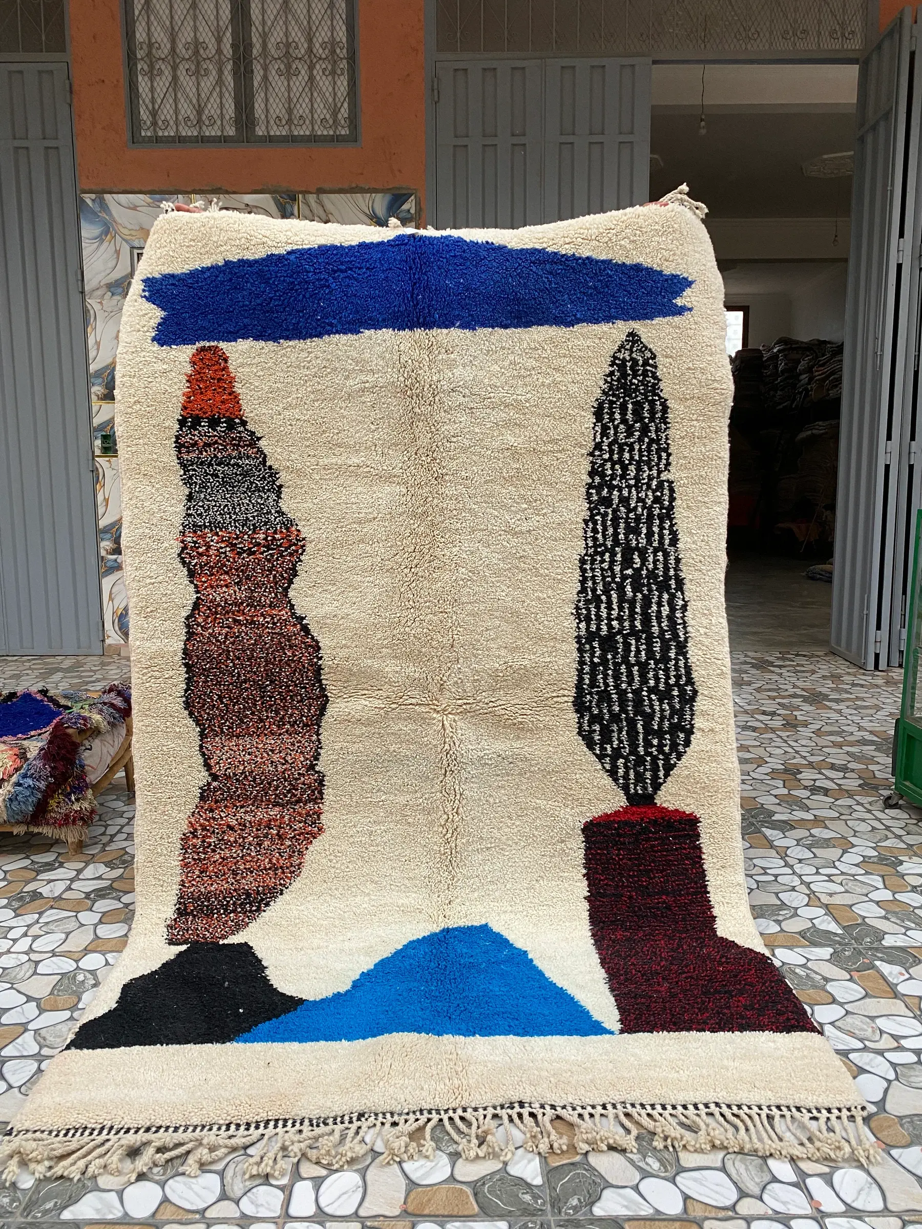 Cobalt Blue Abstract Moroccan Rug, the whole rug held up in front of the workshop