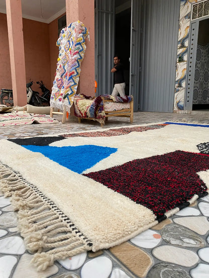 Low view of the rug on a tiled patio with a doorway, a man and other rugs in the background