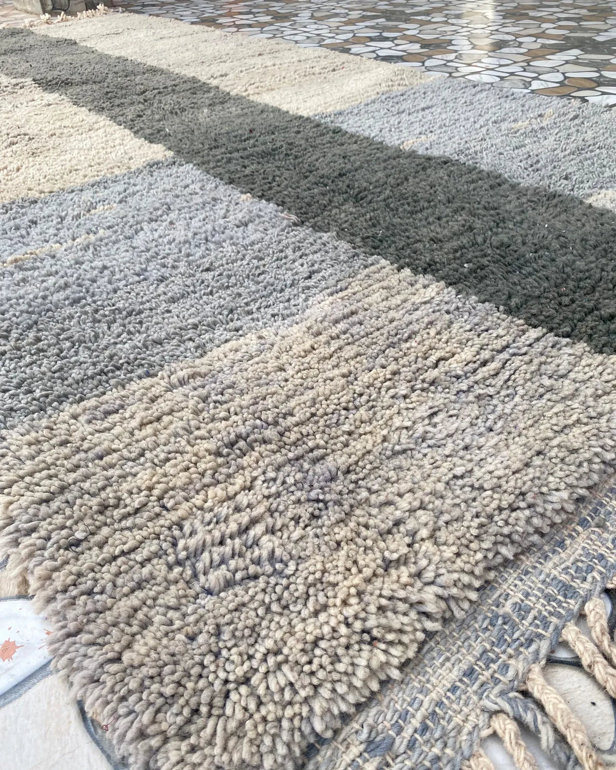 Gray and Charcoal Beni Ourain Rug, seen at an angle on the workshop floor