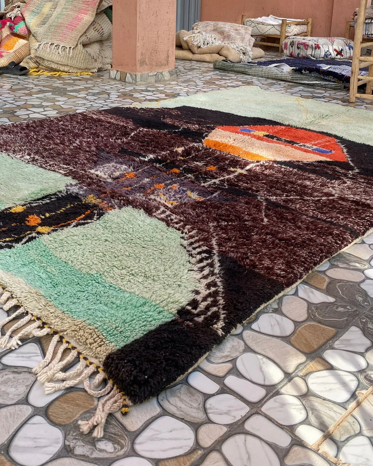 Mint and Plum Abstract Moroccan Rug, seen at an angle on the workshop floor