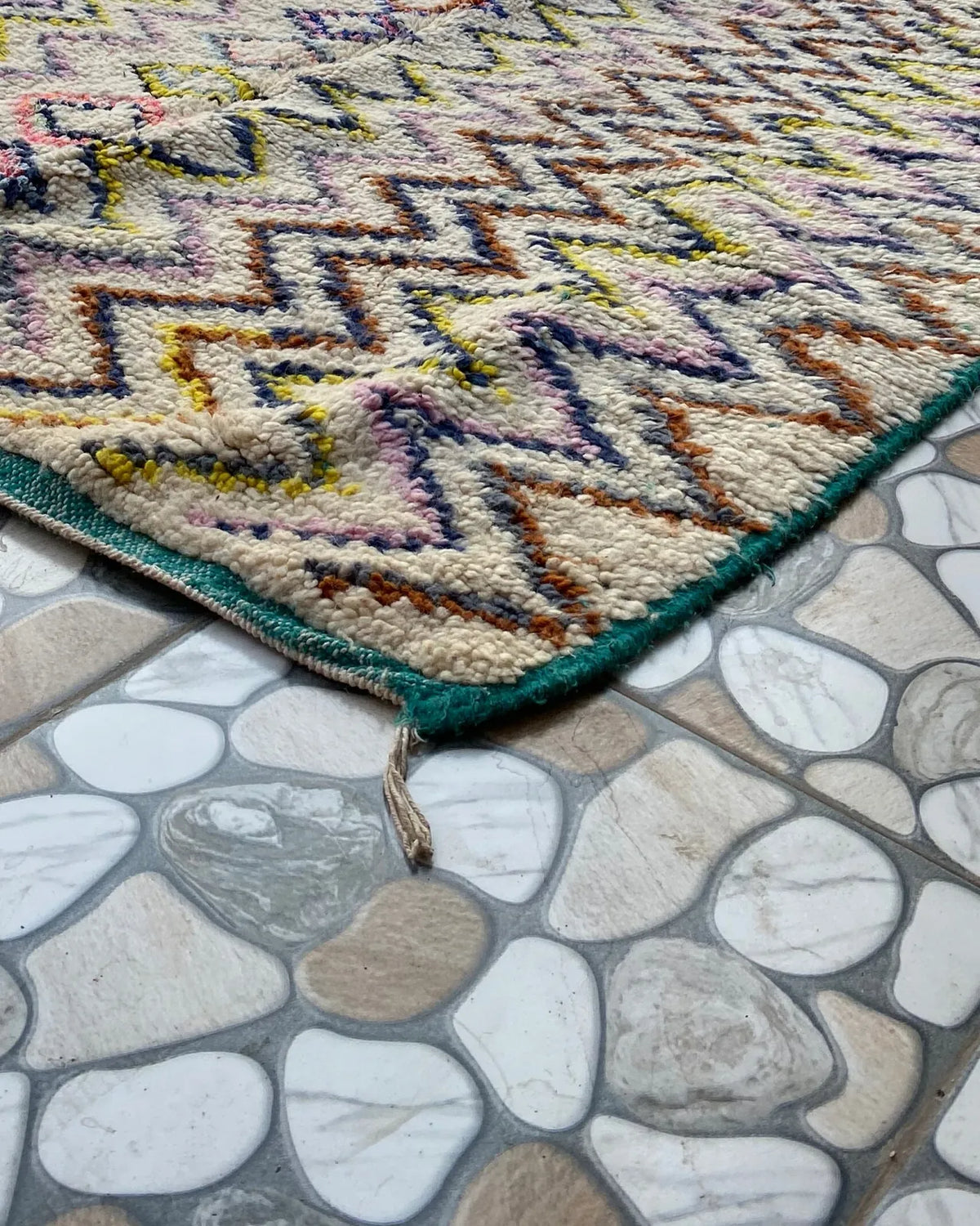 Multicolor Zigzag Moroccan Rug, seen at an angle on the workshop floor