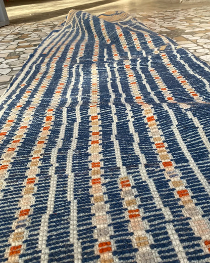 Navy Blue Stripe Moroccan Rug, seen at an angle on the workshop floor