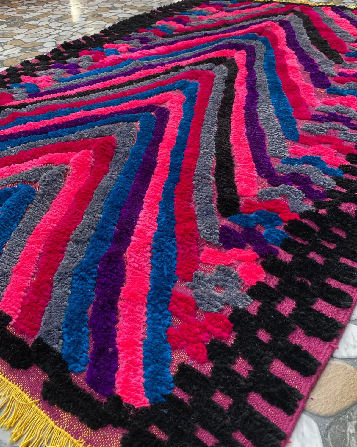 Pink and Blue Chevron Moroccan Rug, seen at an angle on the workshop floor
