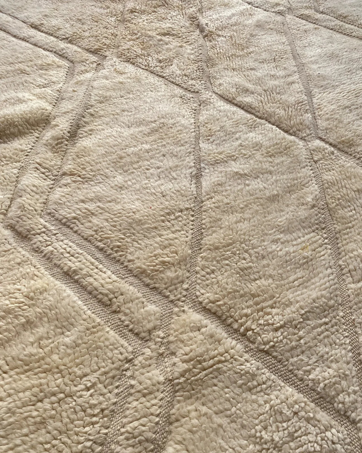 Close-up of the deep ivory wool pile of a Beni Ourain rug